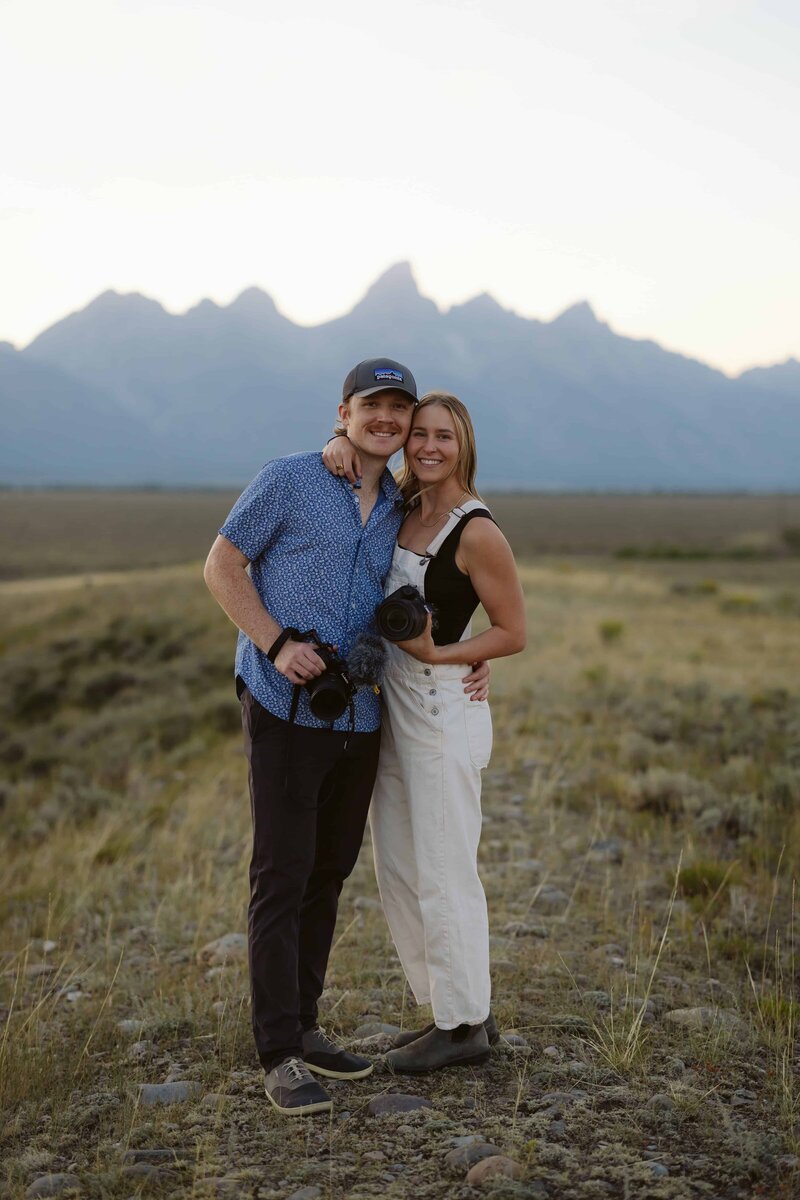 Lauren and Matt of Intimate Adventures Media standing in front of the Sawtooth Mountains in Stanley, Idaho after a wedding shoot