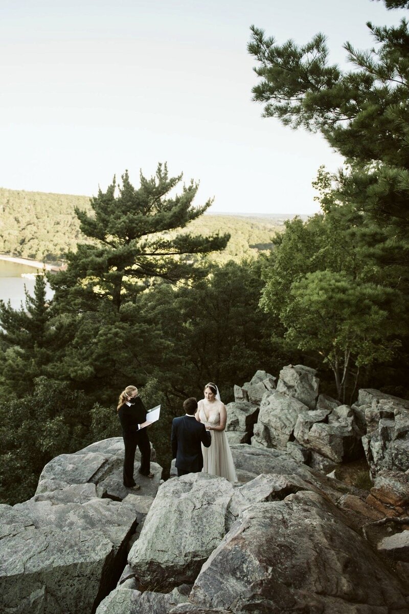Bride and groom exchange vows on a mountaintop during elopement