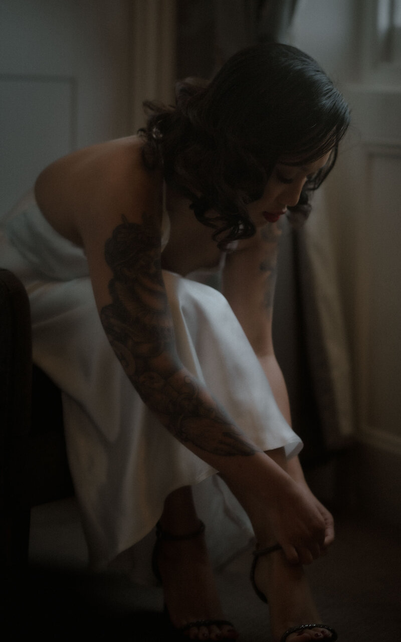 Bride tying her shoe in a peaceful, intimate moment, preparing for the big day. A beautiful glimpse of the bride’s attention to detail on her wedding morning