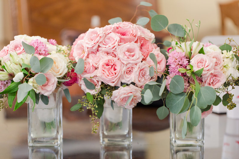 Pink peony bouquets lined up in vases