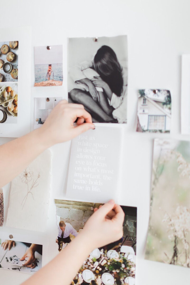 white female hands pinning quote to a mood board