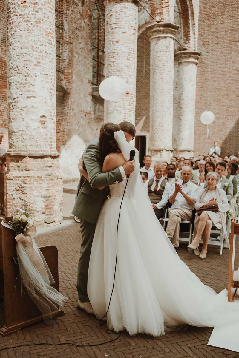 Een danseres die voorover gebogen in de lichtstralen van de zon zit
