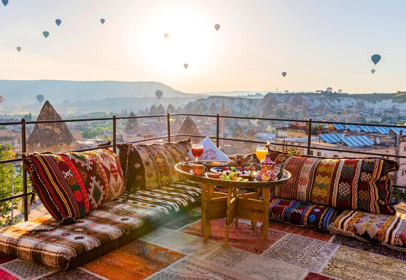Rooftop breakfast with hot air balloons over Cappadocia, Turkey.