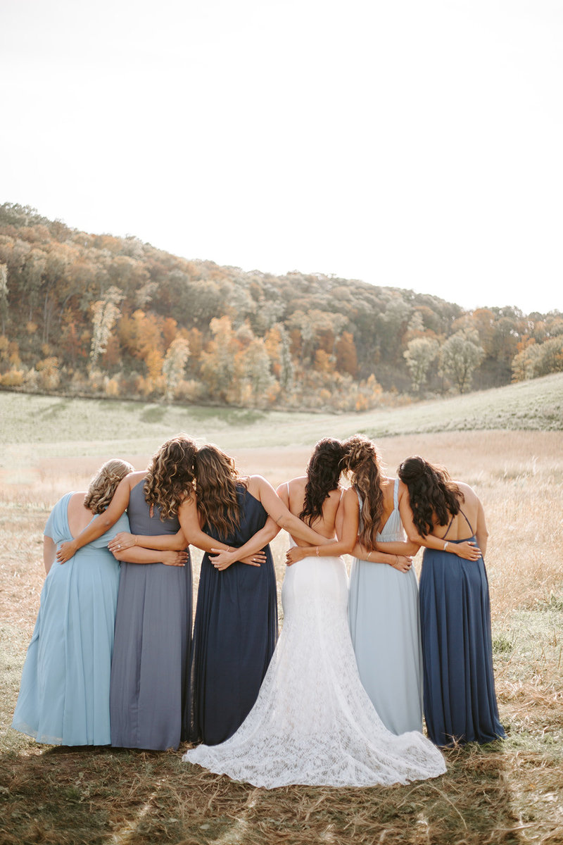 Bride with her bridesmaids facing away from the camera and their heads leaning on each other during a Wisconsin wdding