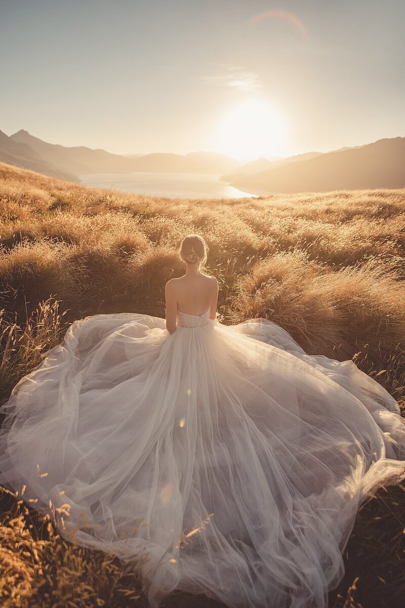 A golden light outdoor photoshoot of a woman wearing a couture dress.