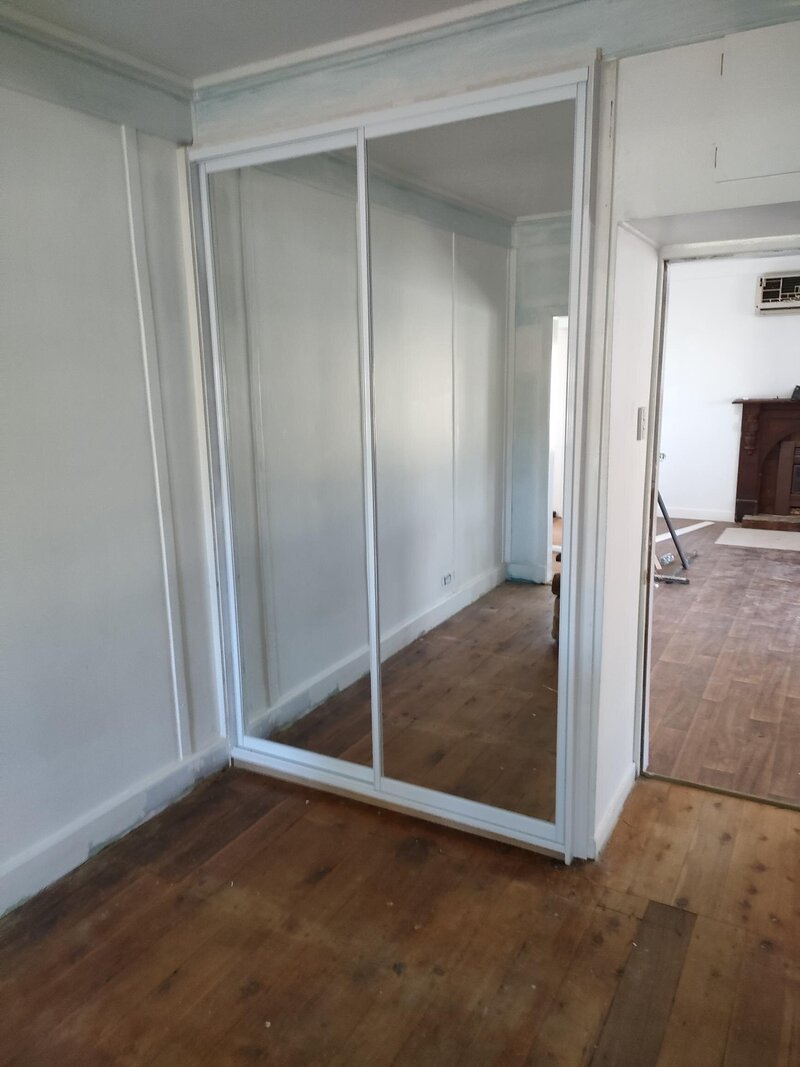 Custom sliding wardrobe doors with aluminium frames, designed for functionality and sleek style in modern bedrooms.