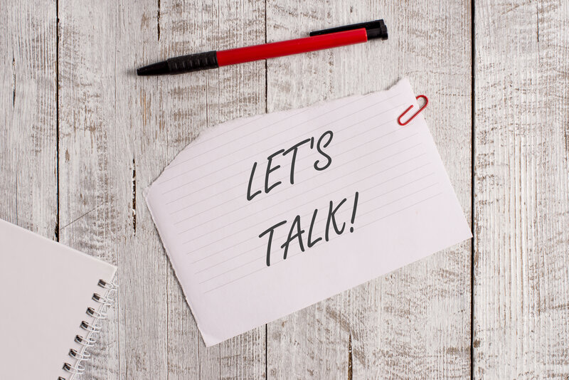 Notebook paper reading “Let’s Talk!” beside a pen, encouraging open conversation and safe support at Peaceful Empowerment Counseling