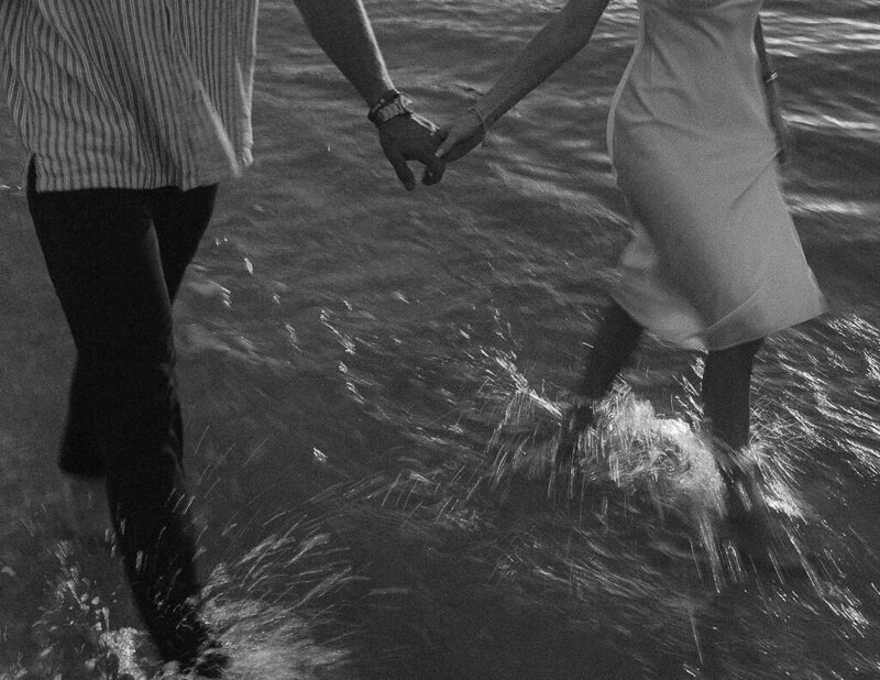 couple playing in the ocean taken by engagement photographer naples fl