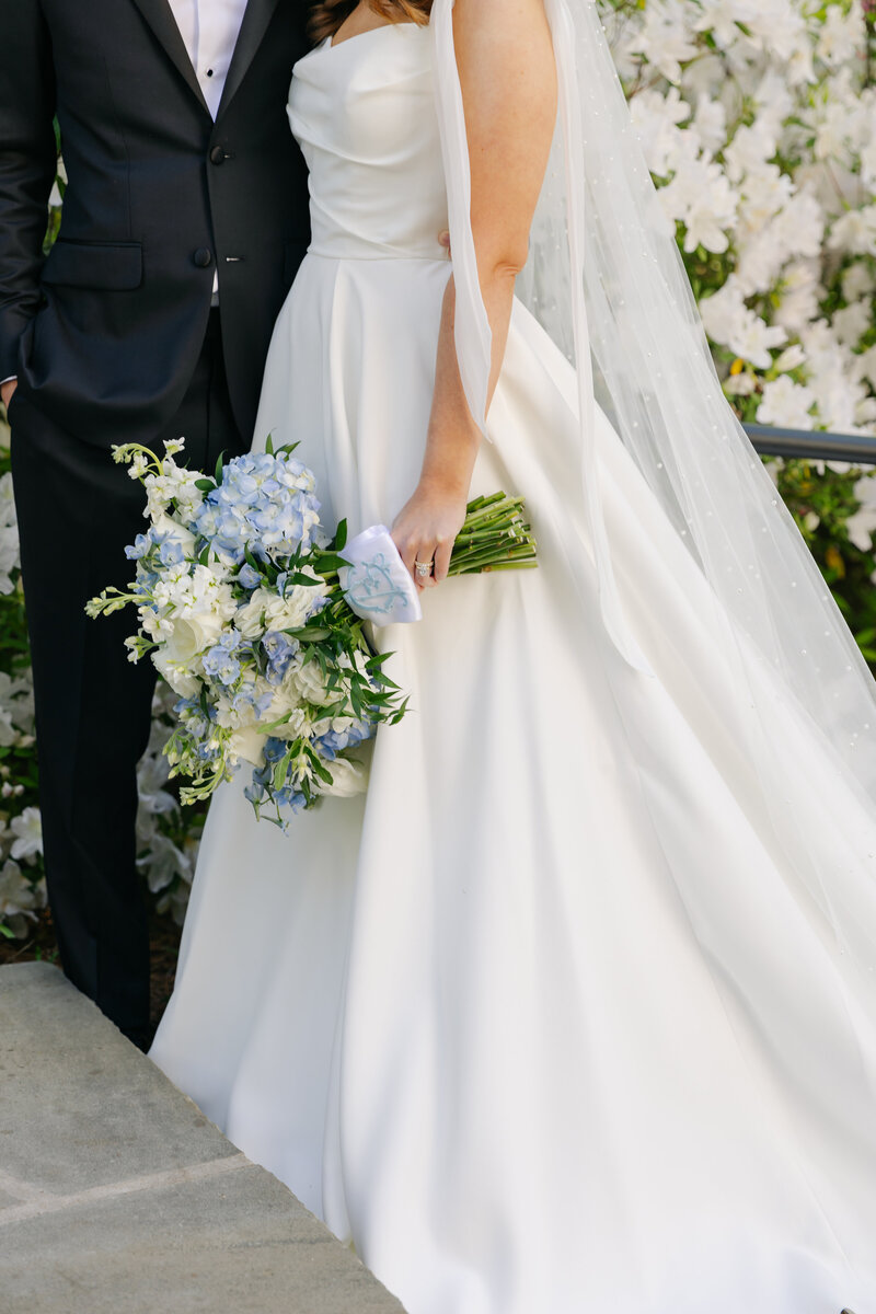 bride holding bouquet and posing with groom for portraits
