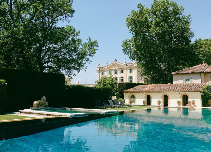 Stately luxury wedding venue Chateau de Tourreau captured from the glistening teal pool