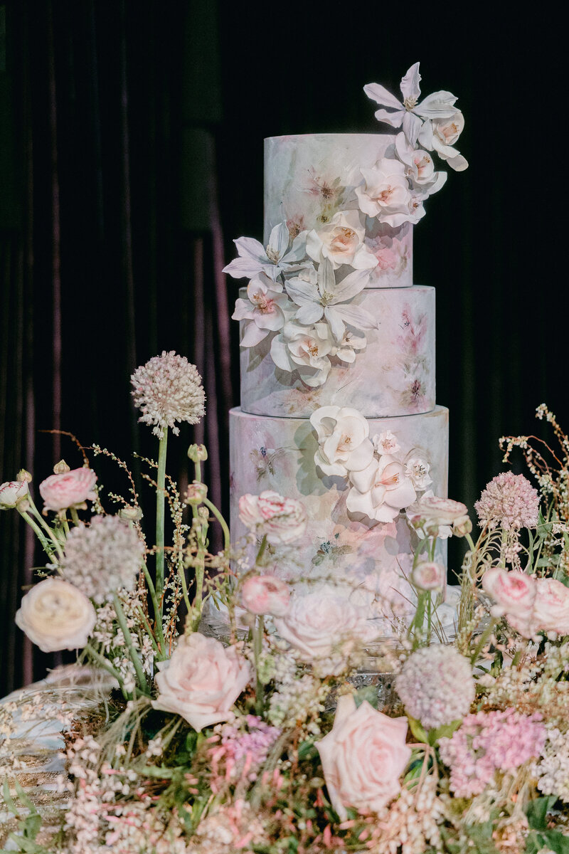 A breathtaking hand-painted floral wedding cake adorned with delicate sugar flowers, showcased at a luxury wedding at the Westin Savannah. Designed by Allison Design, this artistic cake perfectly complements the romantic floral decor, creating an unforgettable reception centerpiece.