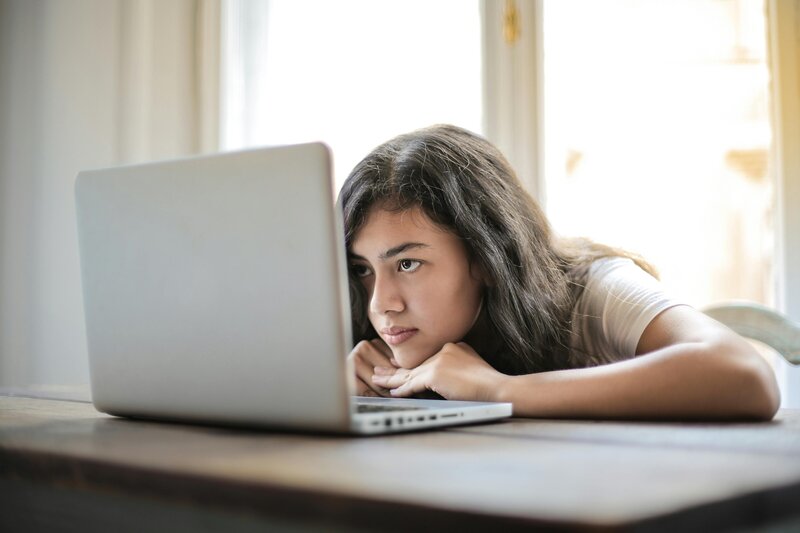 Student resting her chin on her computer