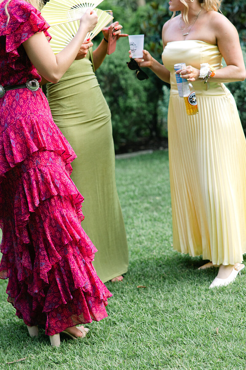 Wedding guests in colorful dresses photographed candidly by austin photographers Erin Marcin and assistant MNPhotoCo