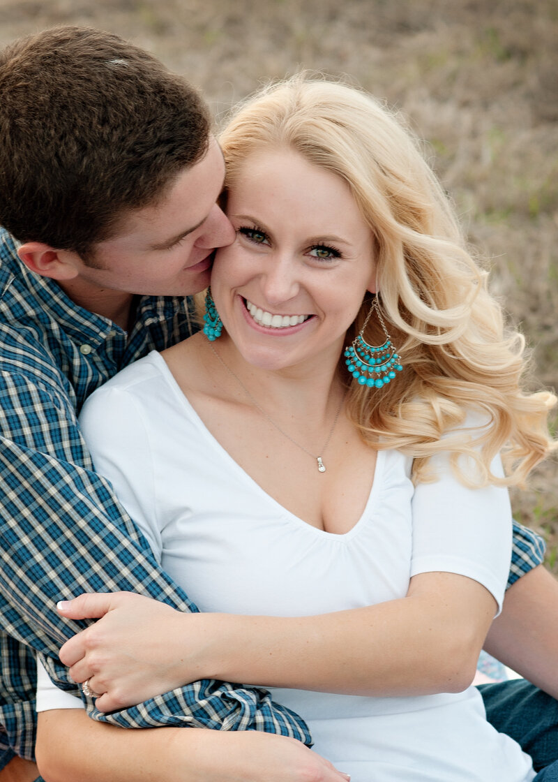 man hugging his bride to be and kissing on the cheek during their engagement session with Winter park photographer Melissa Vinsik