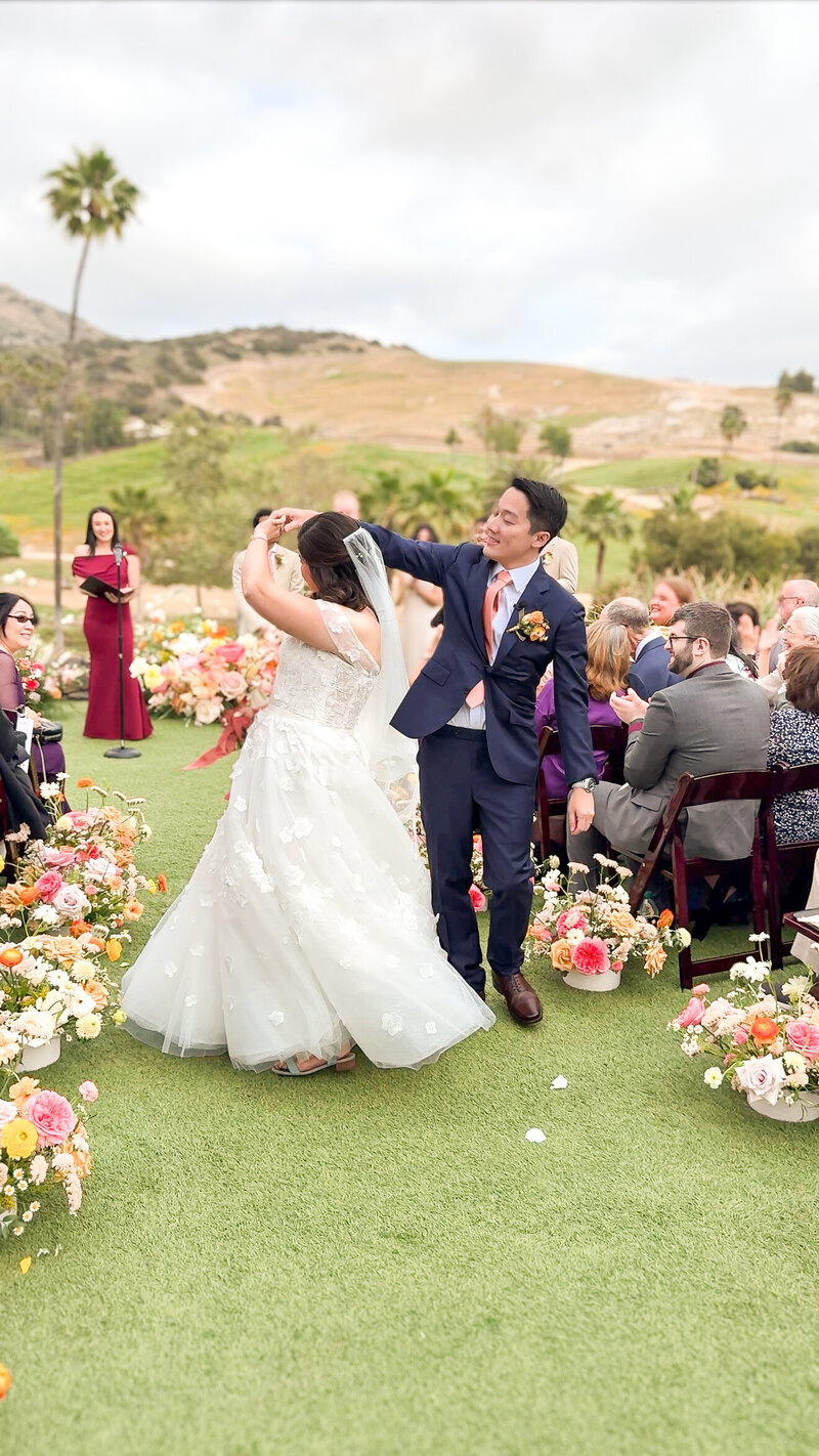 Bride and groom spinning down the aisle during the recessional at the San Diego Zoo Safari Park in Escondido.