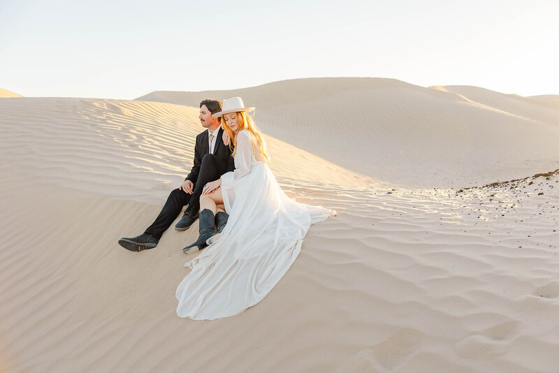 Intimate moment of a bride and groom cuddling up at their elopement at the breathtaking Little Sahara Sand Dunes in Utah.