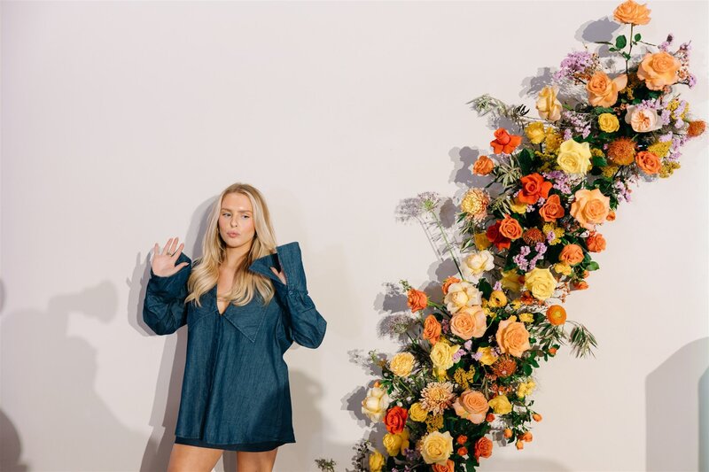 Statement floral installation for Austin corporate event styling, featuring orange, yellow, and lavender florals with a playful fashion-forward vibe.