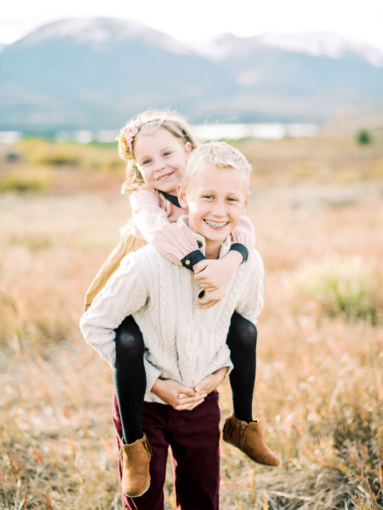 Brother and sister laughing together during autumn family photoshoot in Keystone