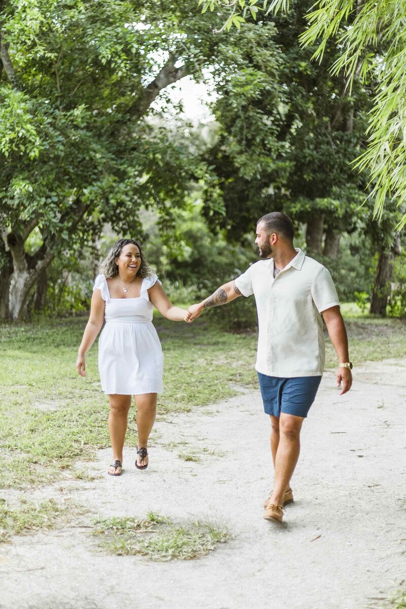 Man leads girlfriend by the hand towards the camera