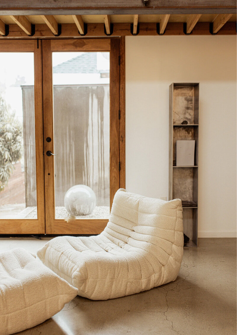 Togo Ligne Roset in beige op een betonvloer en houten kozijn