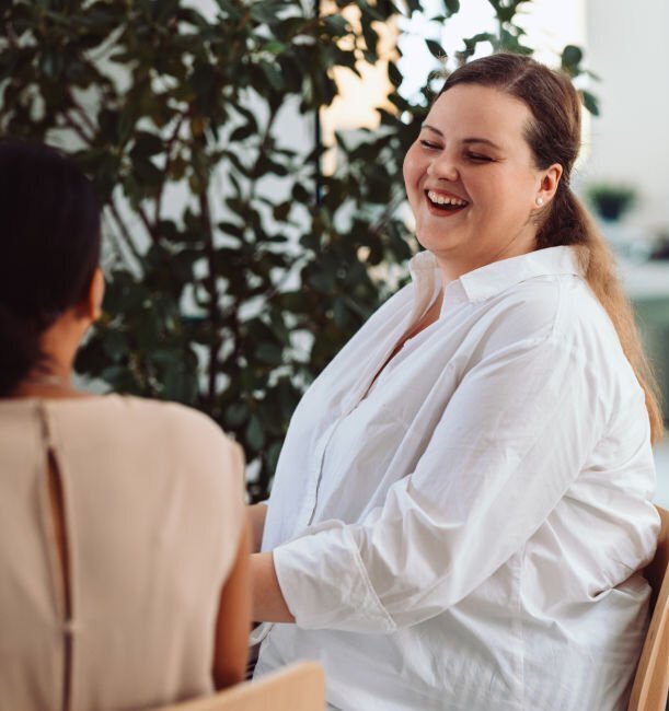 plus size woman in white shirt laughing