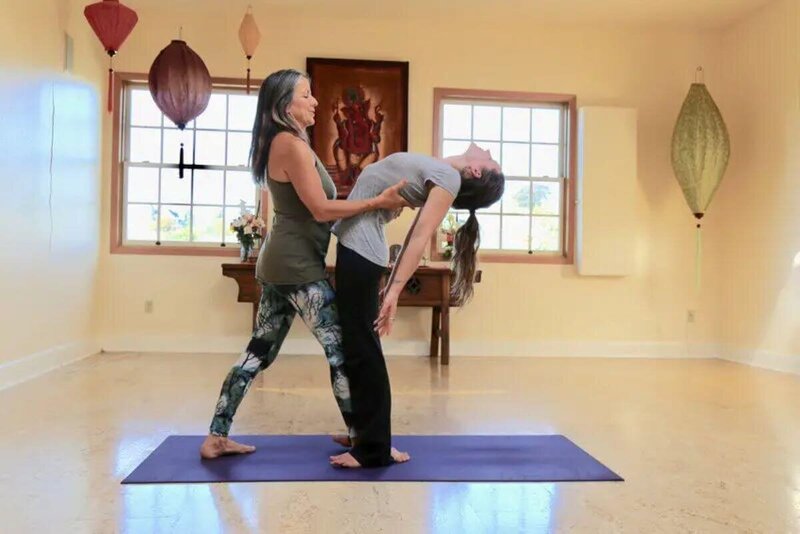 Yoga therapy training student learning wheel pose backbend assists California