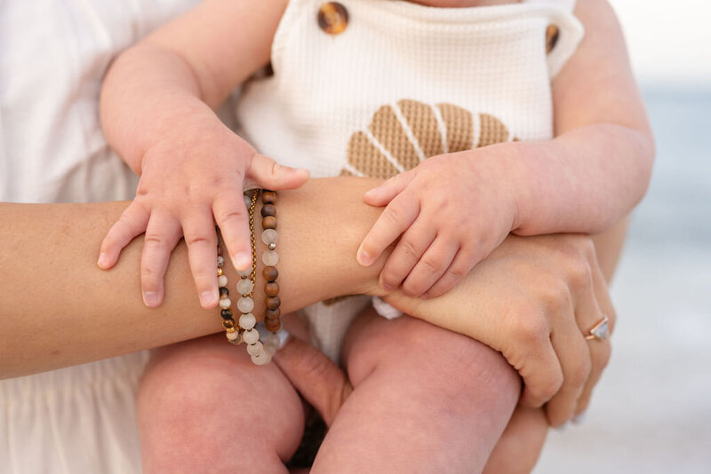 a closeup of a mother's arms wrapped around her baby