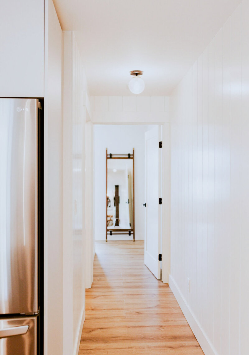 Shot of the white hallway and light brown natural wood floors in the bridal suite.