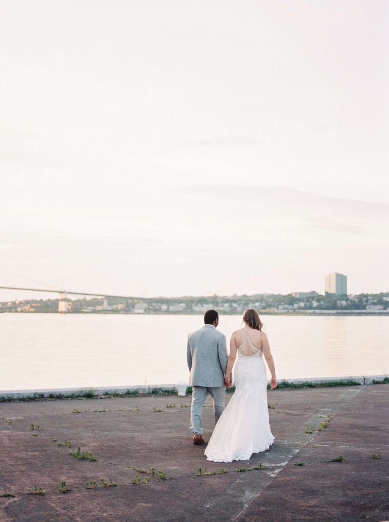 Bride and groom walking along shore at Halifax, Nova Scotia