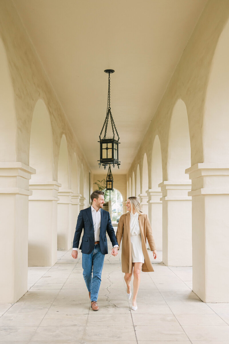 A refined engagement moment captured at Brophy Chapel in Phoenix, Arizona. Dressed in timeless style, the couple walks through the chapel corridor in a scene filled with soft romance and architectural charm—perfect for couples seeking elevated, editorial-inspired engagement imagery.