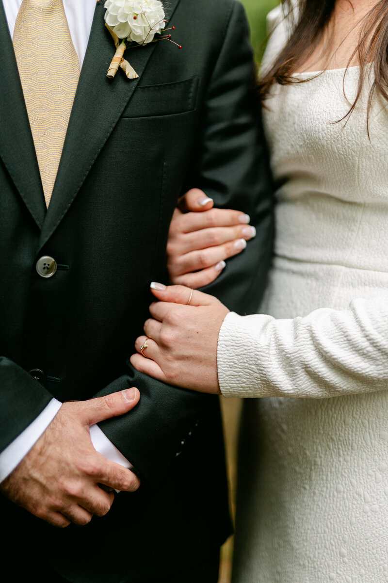 Close up of bride holding groom's arm