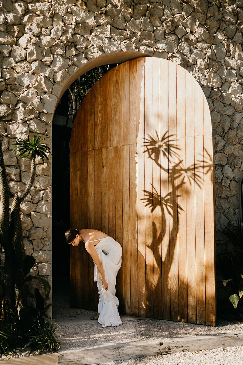 Bride fixes her shoes at destination elopement in Spain.