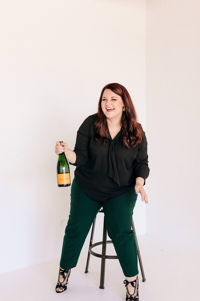 Photographer, Emily, smiles and celebrates with champagne