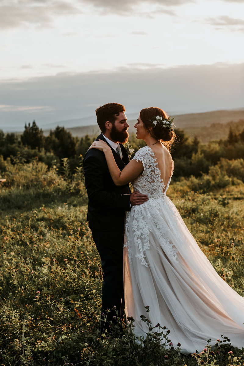 A bride and groom dance at sunset