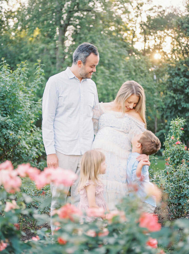A mother, father, and their young son and daughter stand in the Bon Air Rose Garden during their Northern Virginia Family Session