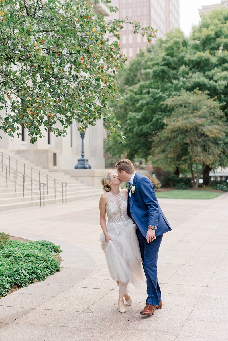 bride and groom kissing outside the ohio state house taken by ashleigh grzybowski cincinnati ohio wedding photographer