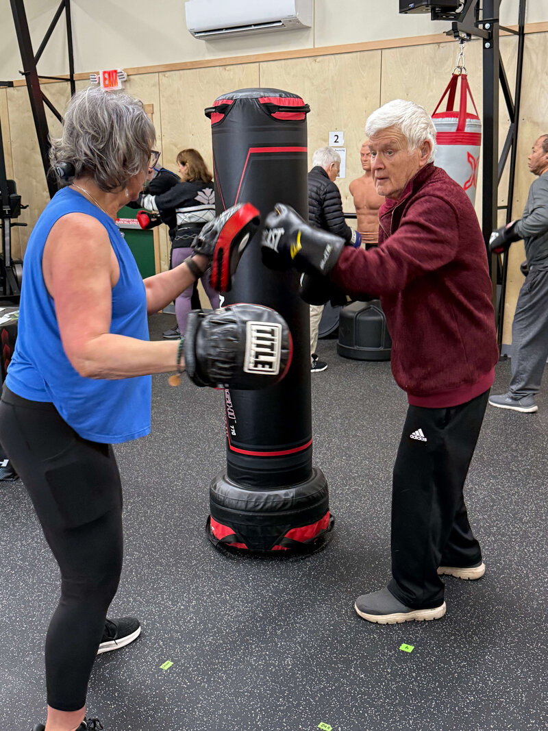 Coach Lori and a warrior in the Warriors gym in Eugene, representing one of the Oregon Parkinson's resources offered by OPWF.