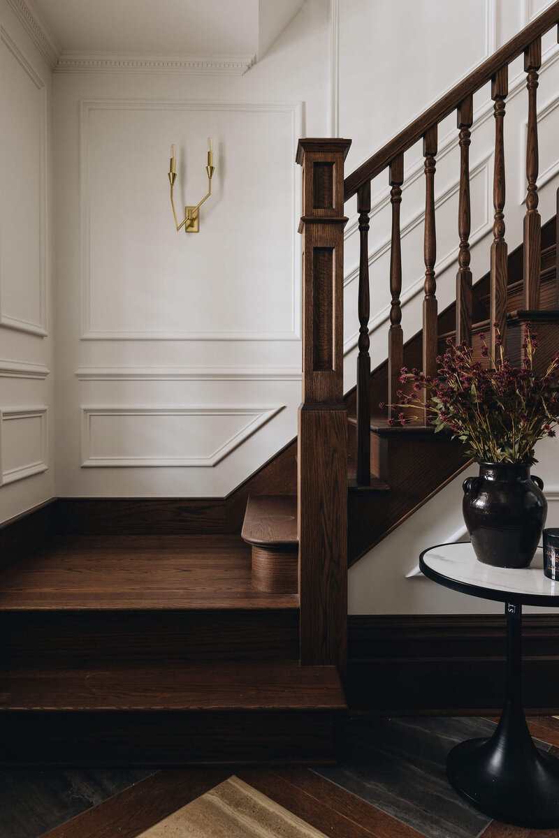 Dramatic traditional staircase with dark wood and moldings