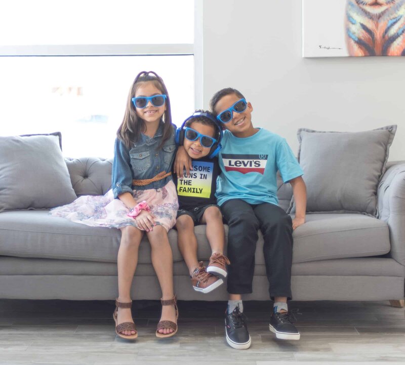 Mixed Race Kids Posing on Couch at Dental Office