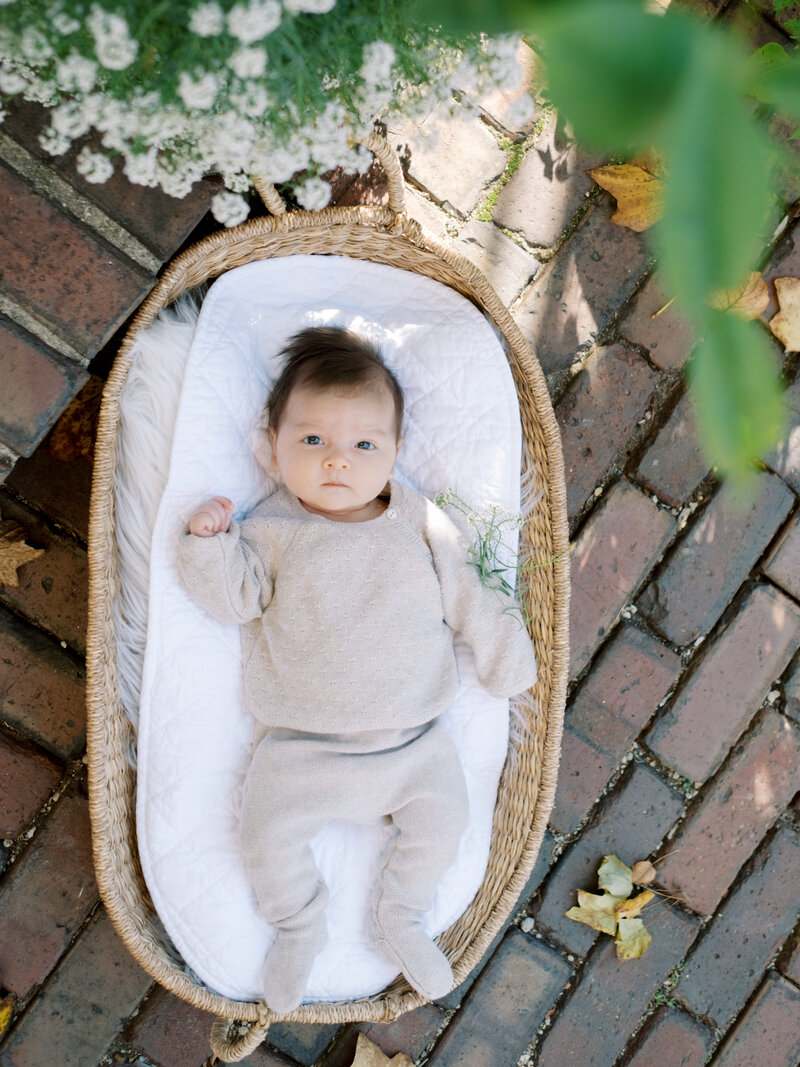 mom sitting on her smiling down looking at newborn daughter