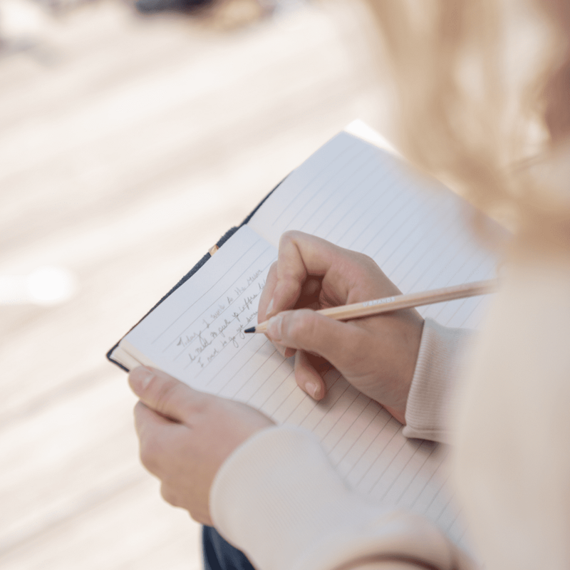 Photo d'une personne en train d'écrire dans un carnet