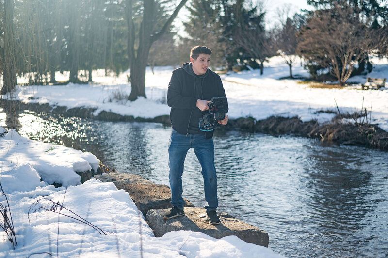 Jacob holding a camera while shooting an outdoor session in the Lehigh Valley.