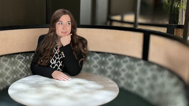 Hayley David, Founder of Money Rebel and business strategist sitting at a table. 