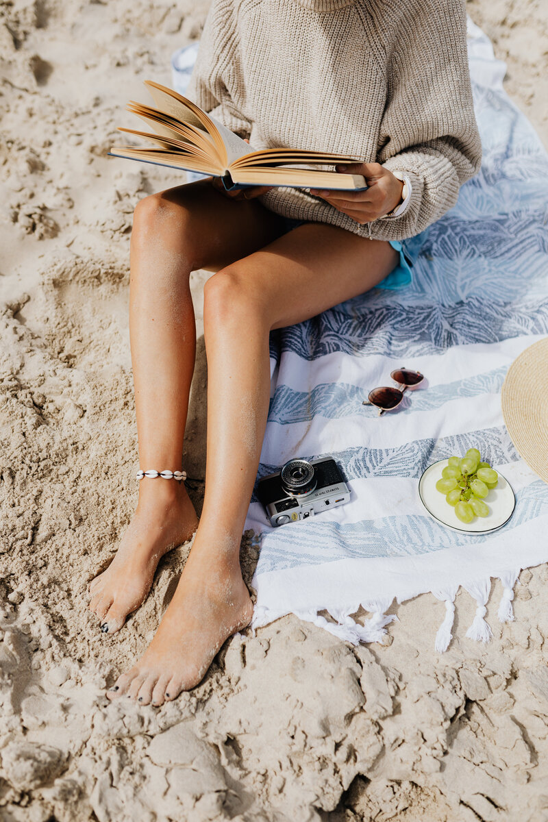 kaboompics_a-woman-reads-on-the-beach-in-the-summer-18645