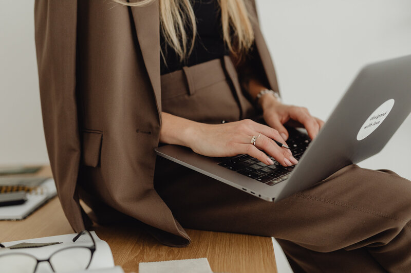 kaboompics_young-entrepreneur-dressed-in-brown-suit-holds-laptop-27936