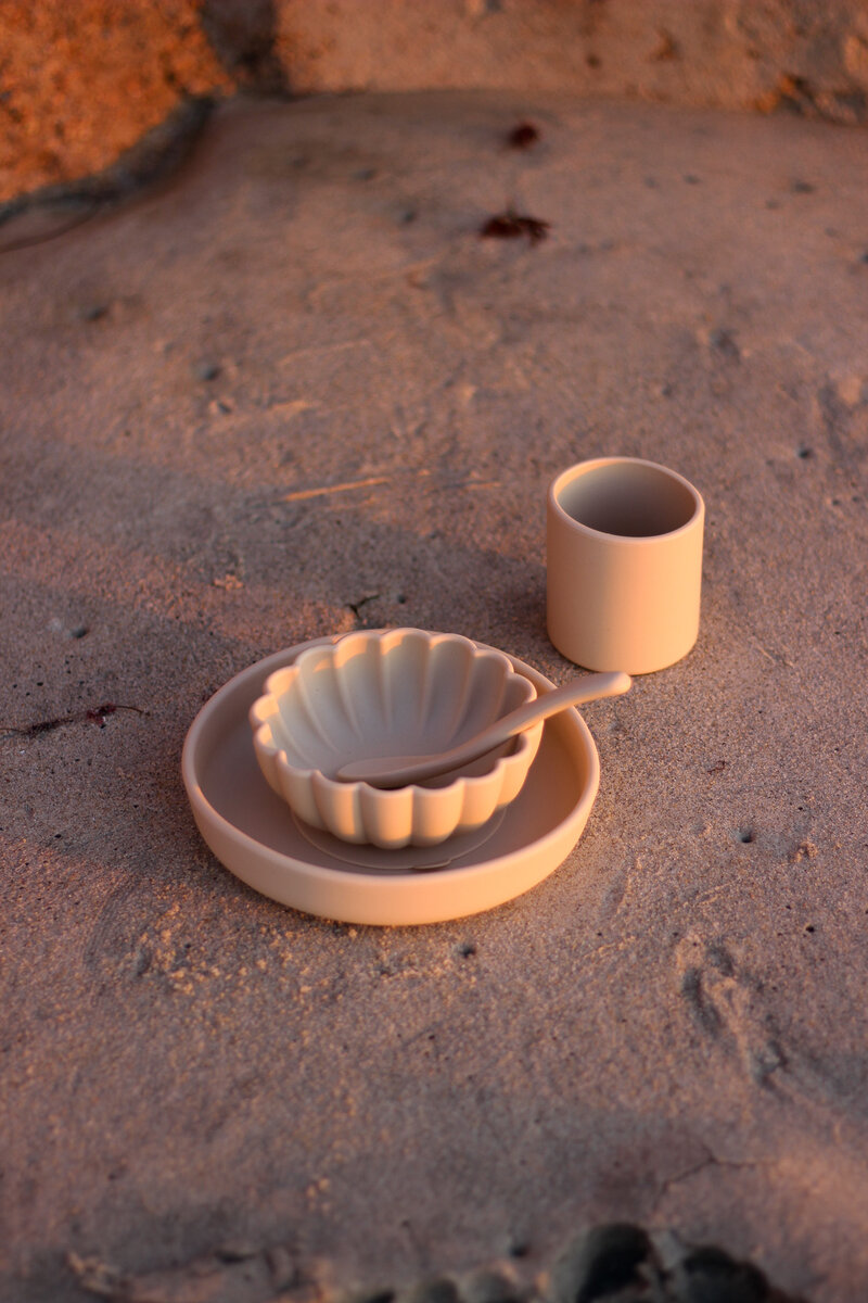 Non-toxic baby tableware set product photography in a beach setting