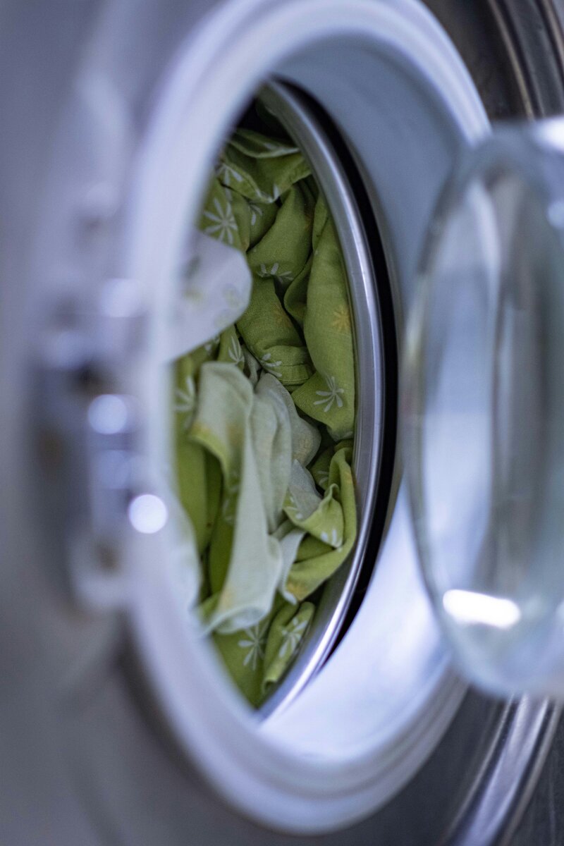 front loading washing machine with green clothing in it