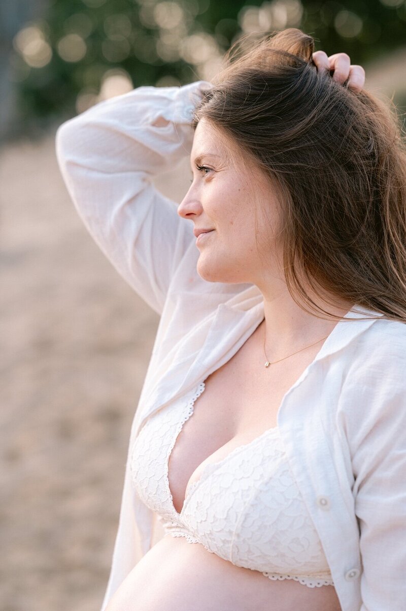 Zwangere vrouw in lingerie in de duinen