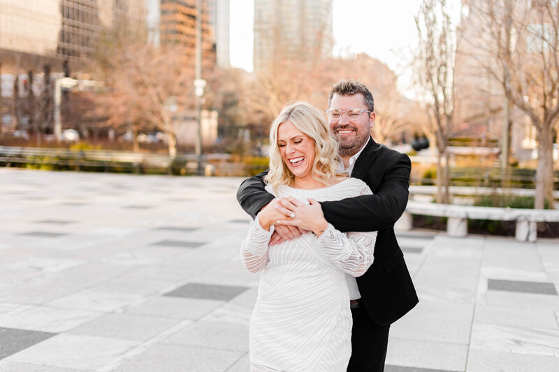 Joyful 'Laughter of Love' engagement photo captured by Style & Grace Photography at Keiner Plaza, St. Louis, MO, showcasing the couple’s happiness and deep connection.