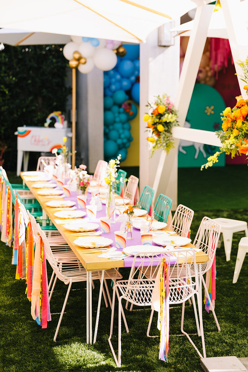 children's unicorn birthday table setting featuring rainbow color streamers